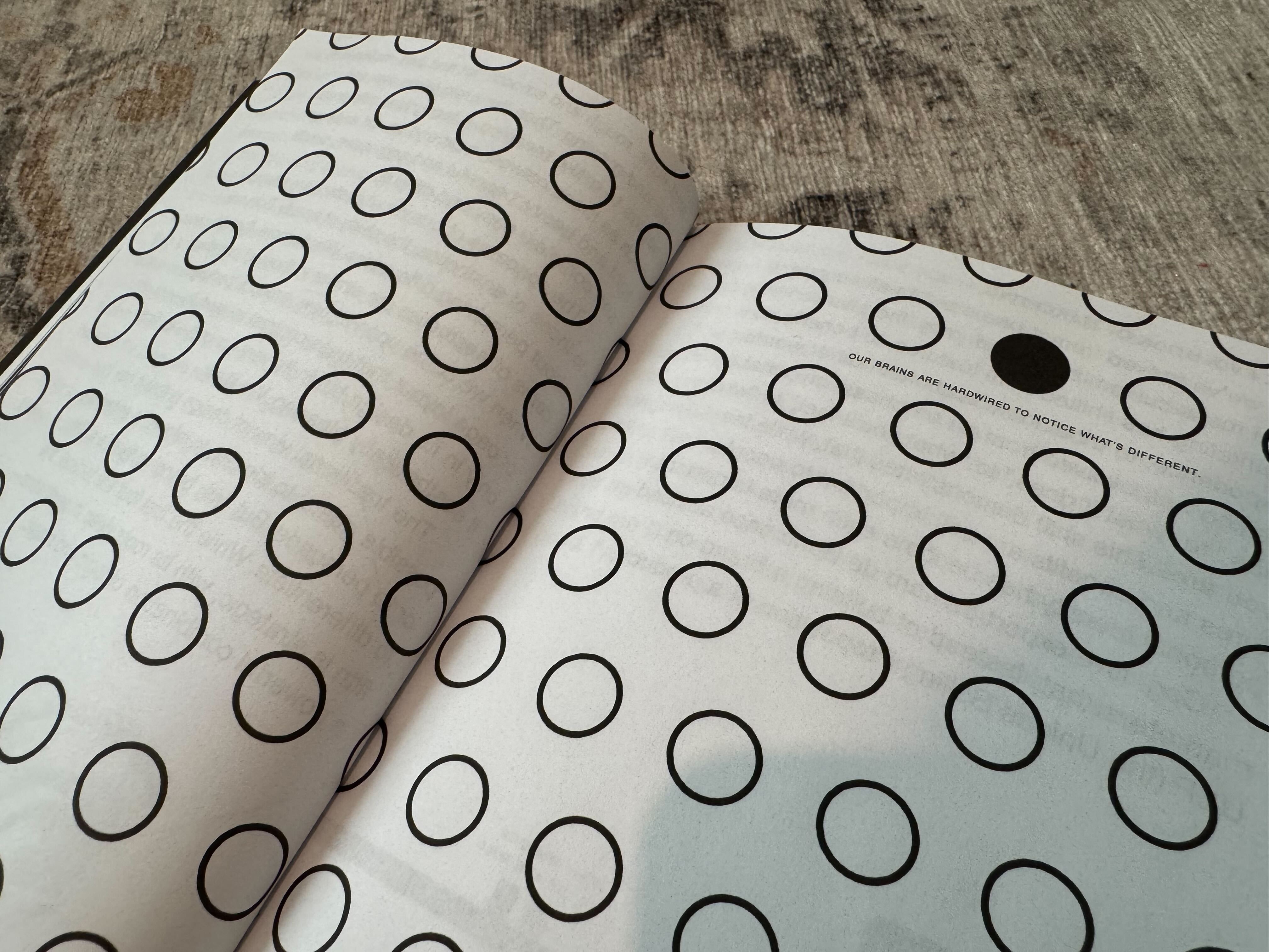 Page from "The Brand Gap" by Marty Neumeier showing a black circle among white circles, symbolizing being different.