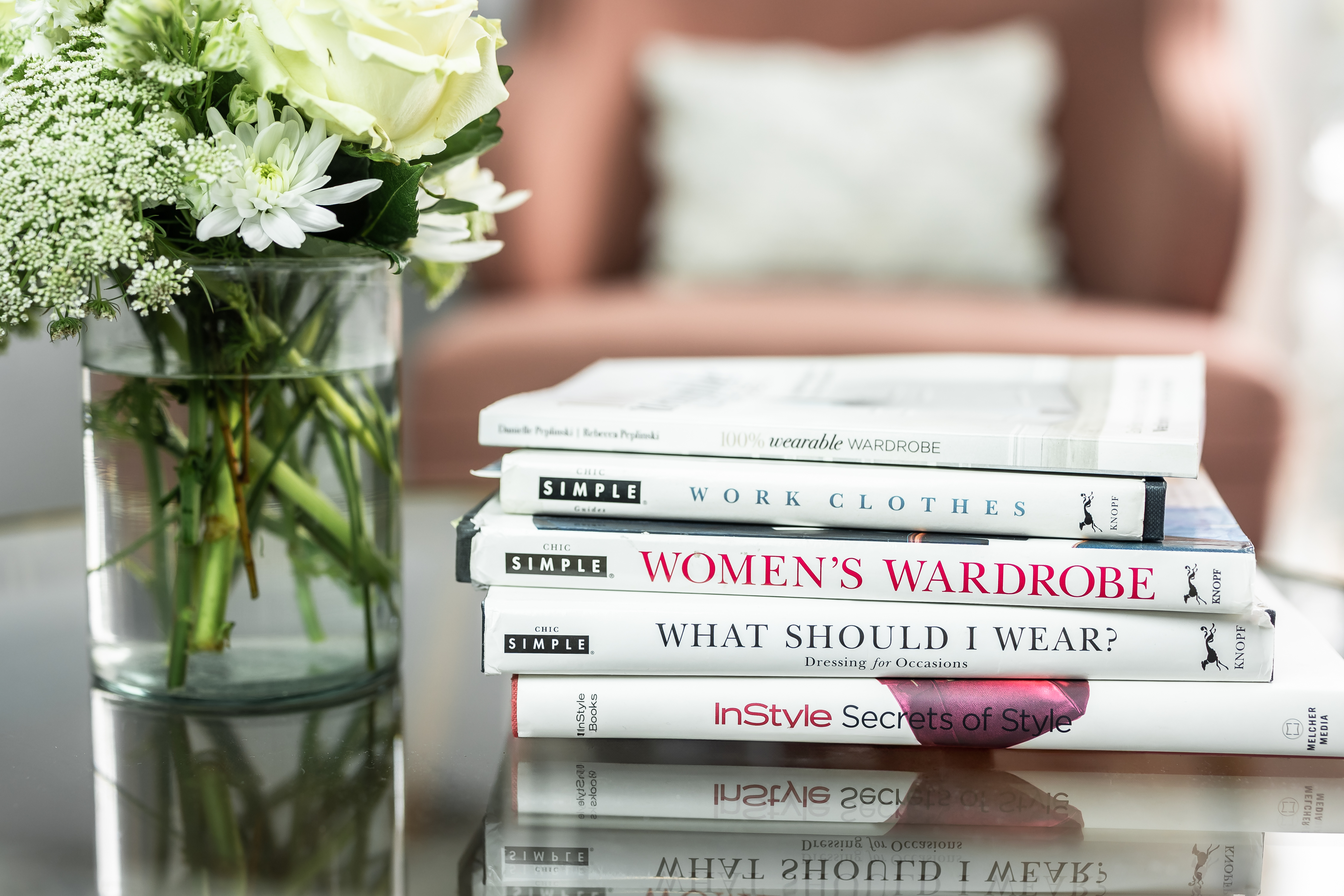 Stack of fashion books on table next to flowers at The Honest Image studio in Albuquerque